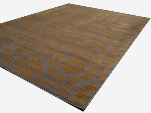 A gray area rug featuring a high-contrast distressed floral pattern in golden orange.