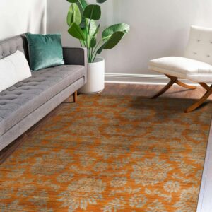Orange and gray floral pattern rug placed on dark wood flooring in a living room setup.