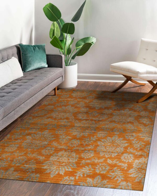 Orange and gray floral pattern rug placed on dark wood flooring in a living room setup.