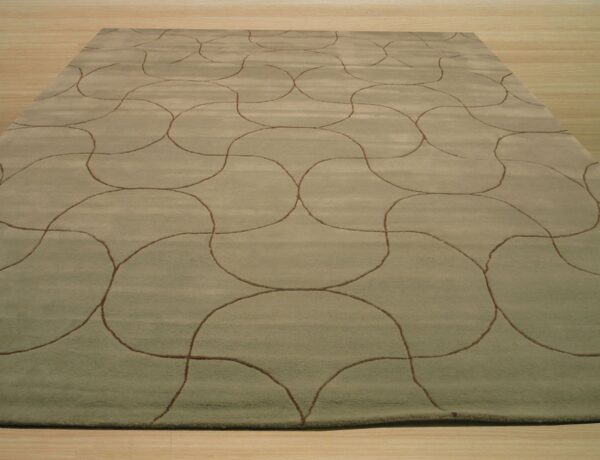 A rectangular sage rug featuring a repeating brown continuous line pattern rests on light wood flooring.