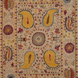 Cream rug with vibrant yellow, rust, and blue floral and large paisley medallions.