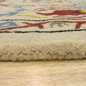 Angled view of a thick-pile cream rug with colorful abstract designs resting on light wood flooring.