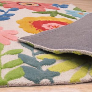 A colorful high-pile floral rug is peeled back, showing the gray backing on light wood flooring.