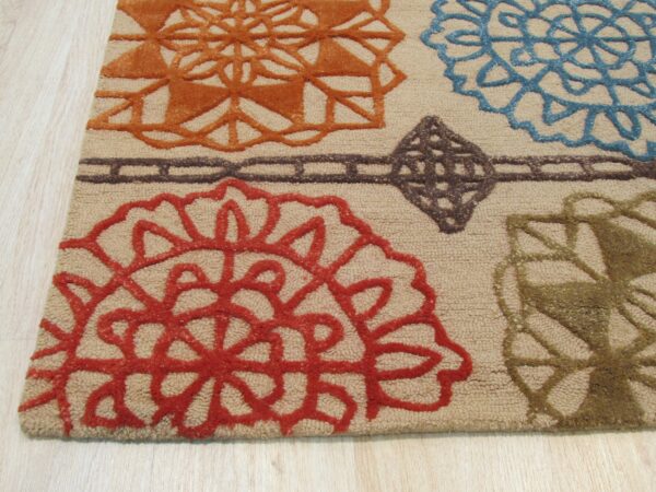 A textured beige rug featuring large medallions in orange, red, blue, and olive green on light wood flooring.
