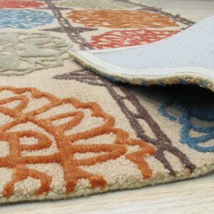 The rolled edge of a beige high-low pile rug displays blue, orange, and brown floral designs on wood flooring.