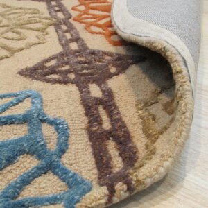 A textured beige rug with raised blue, orange, and brown patterns is curled, revealing the backing on a wood floor.