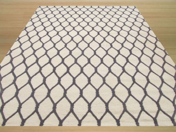 A cream-colored textured rug featuring a dark gray trellis pattern is centered on light wood plank flooring.