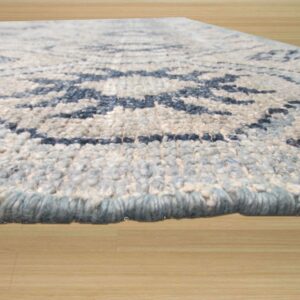 Textured blue and cream shag rug with a visible geometric pattern rests on light wood flooring.