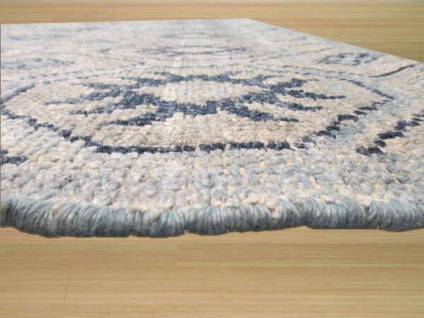 Textured blue and cream shag rug with a visible geometric pattern rests on light wood flooring.