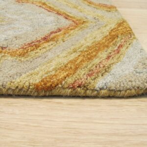 Looped pile rug edge in beige, golden yellow, and reddish-orange zig-zags rests on light wood floor.