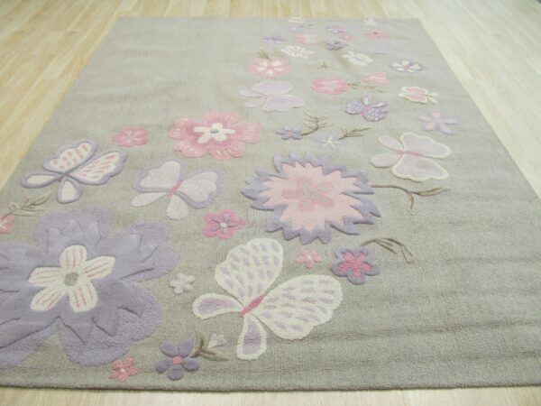 Light gray rug with carved pink and lavender floral and butterfly patterns on light wood planks.