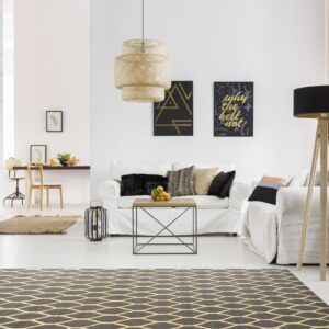 Black and gold diamond rug under a modern coffee table in a bright white living room.