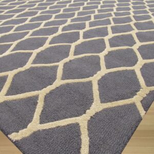 Dark gray rug with a contrasting textured high-low beige geometric pattern resting on light wood floor.