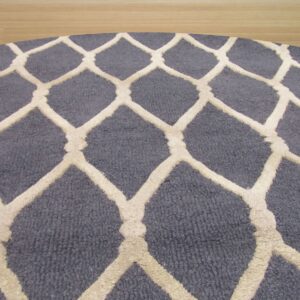 Curved blue rug with raised off-white diamond trellis pattern visible against light wood floor.