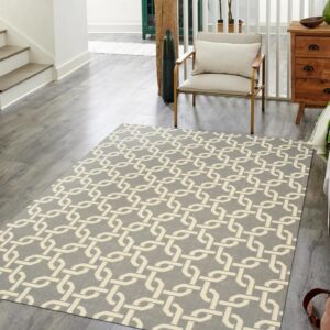 Gray rug with a cream trellis pattern lying on wood flooring next to a modern armchair.