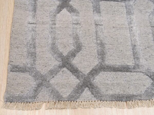 Textured high-low gray rug displaying a large interlocking diamond pattern on light wood flooring.