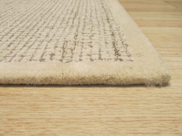 Textured high-pile rug in off-white featuring a raised grid pattern on light wood floorboards.