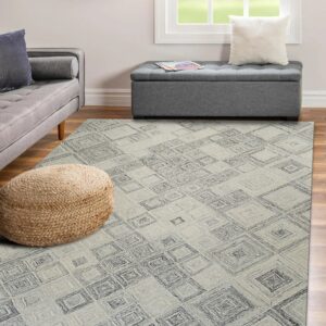 Textured gray rug with dark geometric pattern lays on wood floor next to a gray sofa and woven pouf.