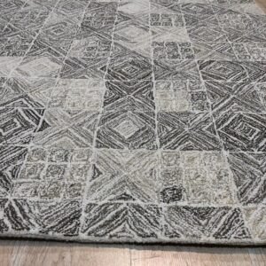 Textured neutral rug featuring alternating diamond and square patterns in white, beige, and dark gray on wood flooring.