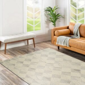 Off-white rug with a textured gray geometric block pattern rests on wood planks near a caramel leather sofa.