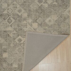 Textured brown and beige geometric rug lying on a wood floor, with one corner folded to show the gray backing.