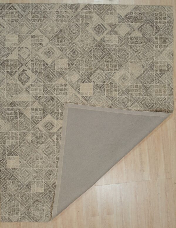 Textured brown and beige geometric rug lying on a wood floor, with one corner folded to show the gray backing.