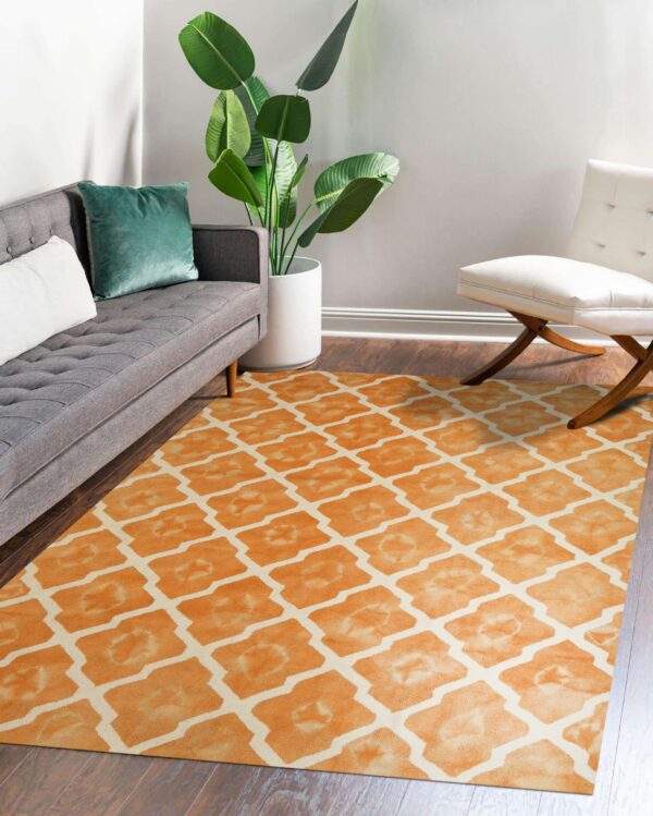 Low-pile rug with a large orange watercolor ogee pattern sits under a gray sofa and white chair.