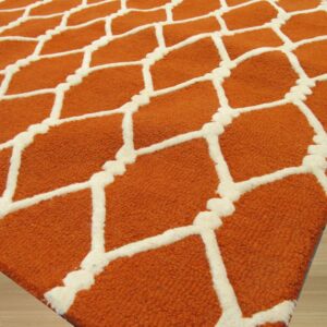 Close-up of a textured orange rug with a raised cream lattice pattern on light wood flooring.