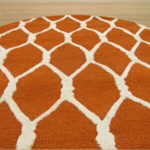 Circular rug with thick pile features a bold orange and white giraffe spot pattern on light wood floor.