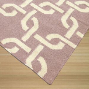 Cream interlocking geometric pattern on a low-pile mauve rug resting on light natural wood plank flooring.