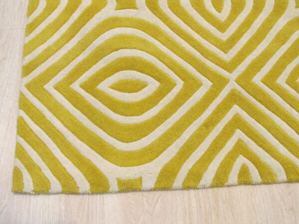 Yellow-green and cream rug featuring a sculpted geometric pattern on light wood flooring.