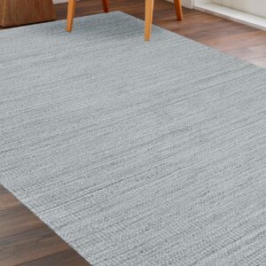 Textured silver-gray rug with horizontal woven lines covering dark wood flooring near chair legs.