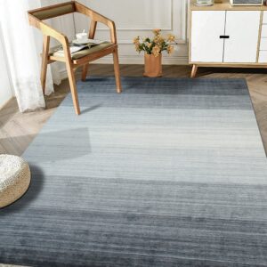 Low-pile gray and light blue striated rug creates an ombre effect under a wooden chair and cabinet.