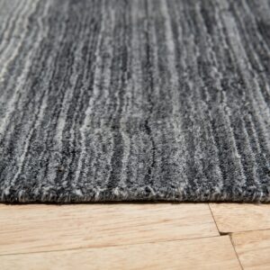 Variegated gray striped rug with medium pile texture rests on light wood plank flooring.