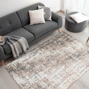 An abstract gray, brown, and white area rug anchors a living room with a dark gray sofa.