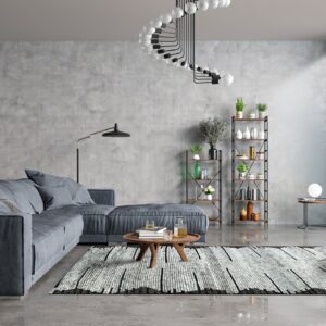 A rectangular black and white shaggy rug with an abstract pattern anchors a modern gray concrete living room.