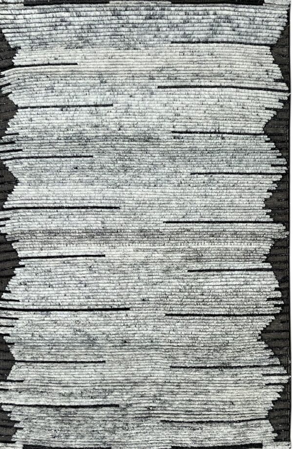 Heavily textured black and light gray rug with horizontal pile strips forming a bold zig-zag pattern.
