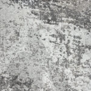 Textured rug with abstract dark gray spots and light gray low-pile areas showing woven foundation lines.