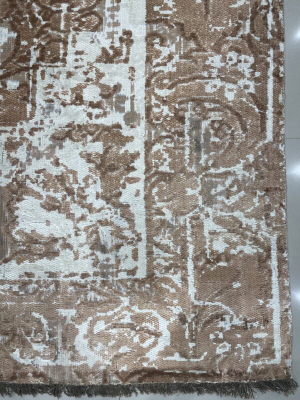 Low-pile rug featuring a distressed brown and cream abstract pattern on a light tiled floor with fringe.