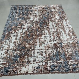 Abstract low-pile rug with white, brown, and blue-gray distressed floral patterns on glossy white tile flooring.