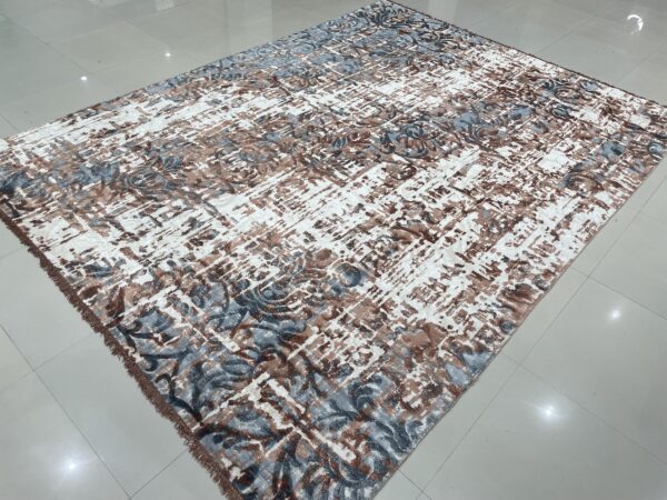 Abstract rug featuring white, brown, and blue-gray patterns, displayed on glossy light gray tile flooring.