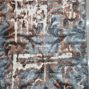 Dimensional abstract rug with stripes and shapes in blue, brown, and white, lying on tile flooring.