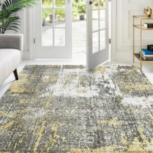 Abstract gray, gold, and white rug placed on a white floor near French doors and a couch.
