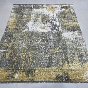 Low-pile rug with a distressed pattern of gold, white, and charcoal gray on tile.