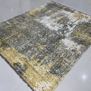 Distressed abstract rug in gold, gray, and white resting on a reflective, light gray tile floor.