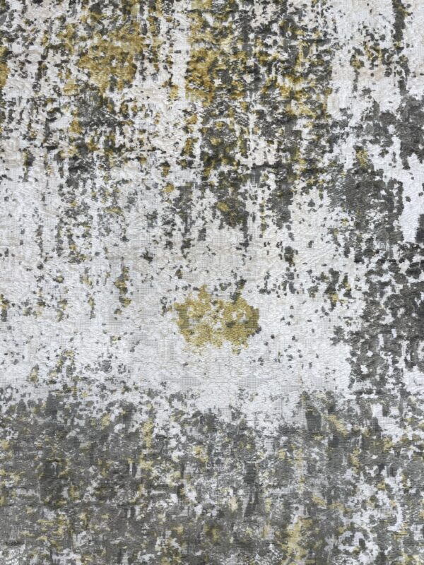 Distressed abstract rug pattern featuring varied pile height in white, dark gray, and yellow-green.