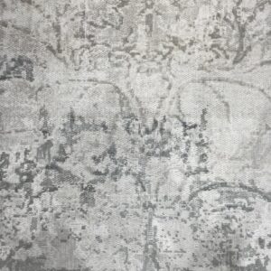 Highly textured gray rug featuring a distressed abstract pattern with visible light and dark variations.