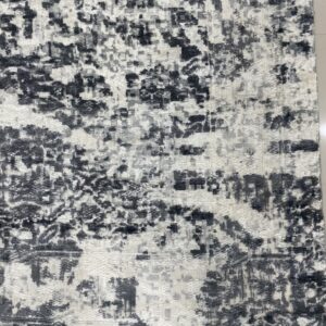 Textured rug featuring high-low abstract black and white patterns, complete with dark gray fringes.