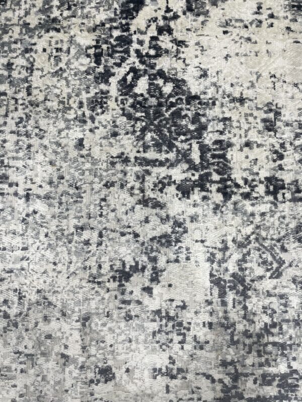 Textured high-low pile rug featuring a heavily distressed abstract pattern in black and light gray tones.