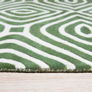 Detailed view of a textured green and white rug with concentric geometric shapes on wood flooring.